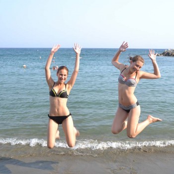 Students jumping in a sandy beach in cyprus